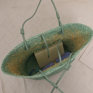 Large woven tote bag in mint green and beige with spacious interior for beach travel