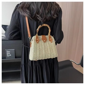 Détail du sac en paille tressée avec poignée en bambou et finitions en cuir