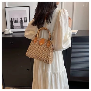 Vue détaillée du sac en paille tressée avec poignée en bambou et finitions en cuir