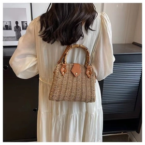 Détail du sac en paille fait main avec texture en fibre et poignée en bambou