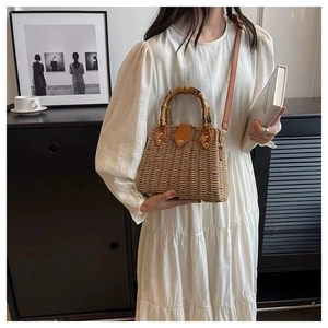 Détail du sac à main en paille tressée avec poignée en bambou et bandoulière en cuir