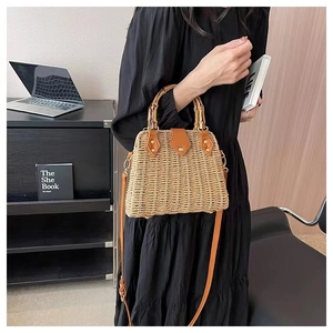 Détail d'un sac en paille tressée avec poignée en bambou et garniture en cuir brun
