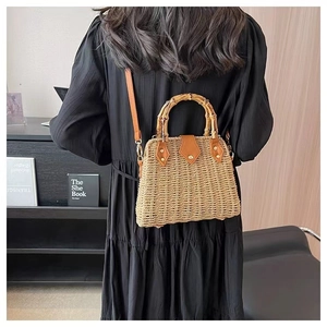 Détail du sac en paille tissé main avec poignée en bambou et lanières en cuir