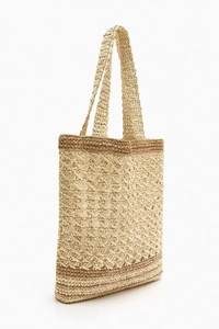 Detail der handgewebten Strohtasche mit Streifentextur und hohlem Strickhandwerk