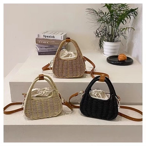 Three-color handmade straw bags with drawstring lining and leather handles in a tiered setup