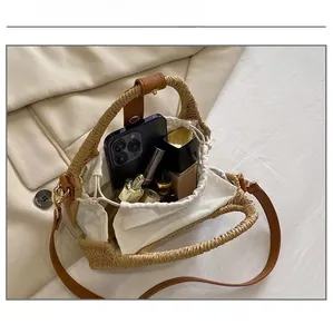 Detail view of woven straw bag interior capacity with drawstring lining and daily essentials