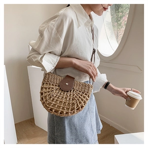 Detail of hand-woven straw crossbody bag with brown leather flap and textured mesh