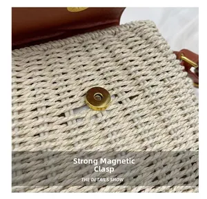 Detail shot of the golden metal magnetic closure on the woven straw crossbody bag