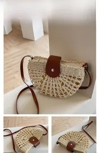 Detail of the woven straw texture and premium brown leather flap with metal buckle
