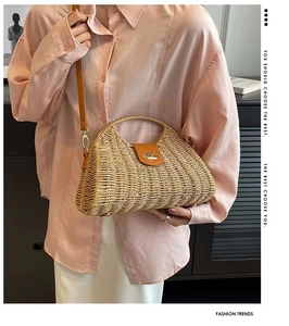 Detail of hand-woven straw shoulder bag with premium brown leather flap and golden lock