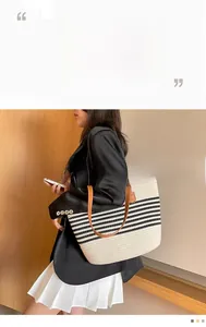 Detail of striped cotton woven tote bag featuring brown leather handles and large capacity