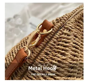 Detail of premium golden hardware hook and brown leather strap on a straw beach bag