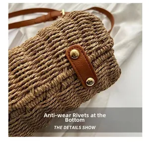 Detail showing the bottom leather patch and protective metal studs of the straw woven bag