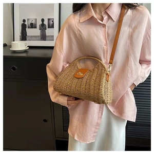 Detail of hand-woven straw bag texture with brown leather flap and golden metal clasp