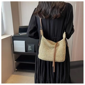 Model wearing a woven paper rope shoulder bag with bohemian texture and leather strap