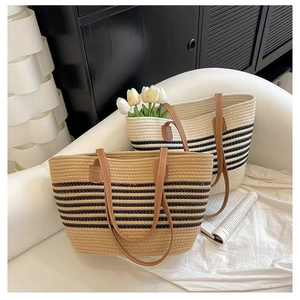 Detail of striped cotton woven tote bags with leather handles in a chic resort style