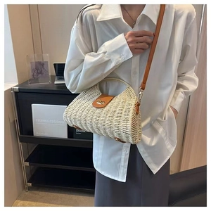 Detail of a straw woven bag with caramel leather trim and elegant metal twist lock closure
