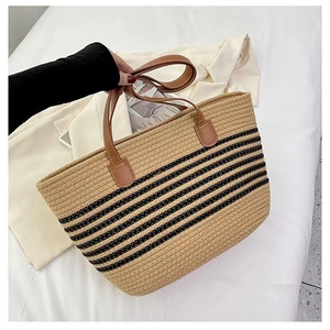 Detail of striped cotton woven tote bag with brown leather handles and stitched finish