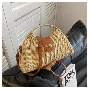 Detail of the straw weaving texture with a brown leather flap and golden metal lock