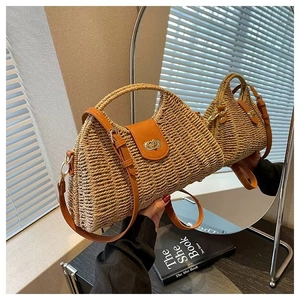 Straw shoulder bag detail with brown leather strap and golden turn-lock closure