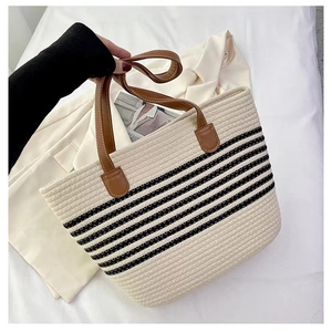 Detail of striped woven cotton tote bag with premium brown leather handles and reinforced stitching