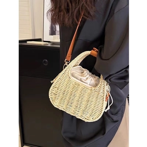 Handcrafted cream straw crossbody bag with brown leather straps for beach vacation style