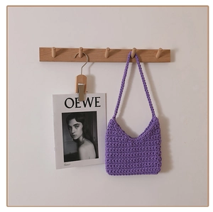 Close-up of purple woven shoulder bag with intricate thick cotton rope knit texture