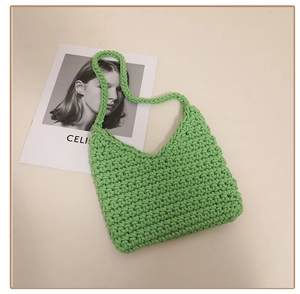 Close-up of light green hand-woven cotton shoulder bag showing intricate knit texture