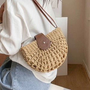 Beige semicircular straw shoulder bag with dark brown leather flap and crossbody strap