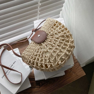 Straw hollow semi-circle crossbody bag with brown leather flap and interior canvas lining