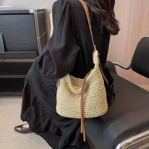 French retro straw shoulder bag with long tassels and brown leather straps for beach vacation