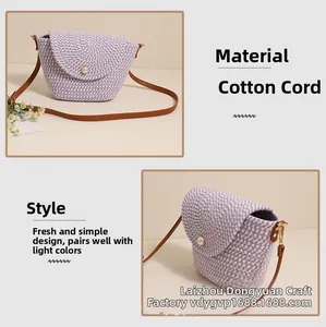 Detail of purple woven shoulder bag featuring a pearl clasp and brown leather strap