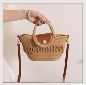 Detail of woven beach bag featuring wave-pattern cutouts and a large pearl clasp accent