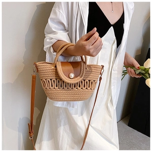 Detail of woven straw bag with pearl closure and brown leather flap for beach vacations