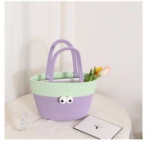Close-up of handmade crochet cotton bag with funny big eyes and green-purple contrast