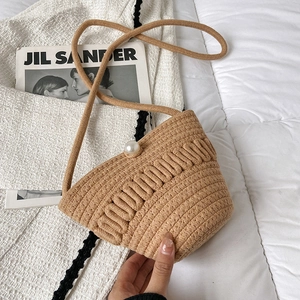 Crossbody woven straw bag in beige with a decorative large pearl buckle and wave texture