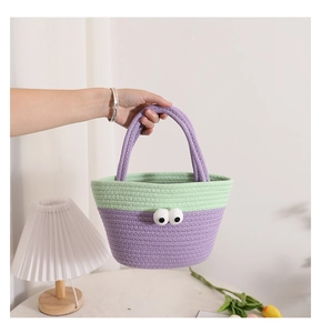 Close-up of a handmade cotton rope woven bag with cute big eyes and a purple handle
