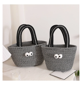Detail of woven cotton tote bags with funny big eyes and black white spiral stripes