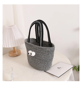 Close-up of black and white woven cotton bag with cute cartoon eyes and sturdy handles