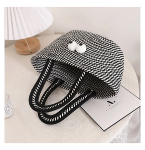 Close-up of geometric woven cotton tote with cute plush eye accents on lace tablecloth