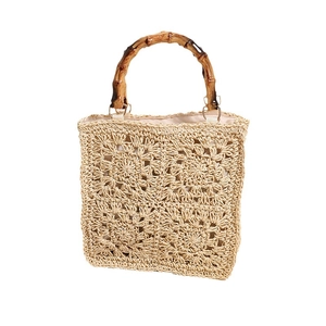 Square beige woven straw tote bag with bamboo handles and floral crochet patterns