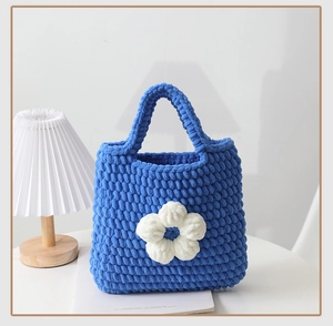 Dettaglio della borsa a mano all'uncinetto blu Klein con decorazione floreale bianca