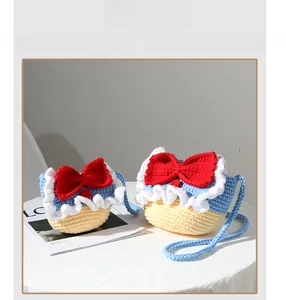 Close-up of handmade crochet bags in two sizes with distinct knit texture and red bow detail