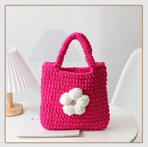 Dettaglio della borsa all'uncinetto fatta a mano rosa magenta con trama a maglia morbida