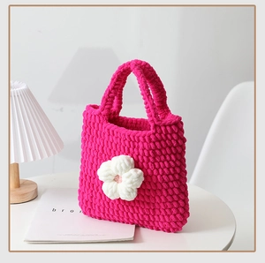 Dettaglio della borsa tote all'uncinetto fucsia fatta a mano con ciondolo a fiore