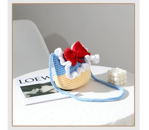 Detail of handmade crochet Snow White crossbody bag with red bow and blue woven strap