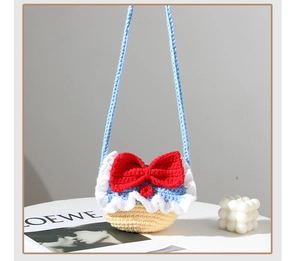 Detail of a handmade colorful crochet mini bag featuring a large red bow and shoulder strap