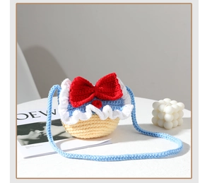 Detail of handmade crochet Snow White crossbody bag with large red bow and frill trim