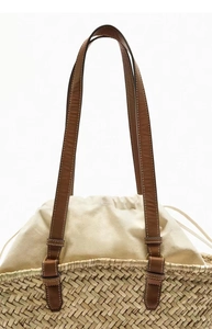 Detailed straw woven basket bag with leather handles and canvas drawstring closure