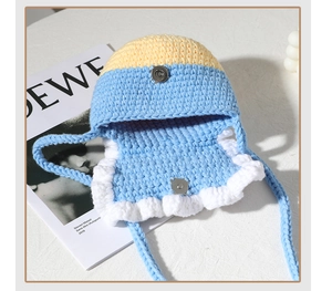 Detail of handmade crochet bag featuring color-block design and metal magnetic closure